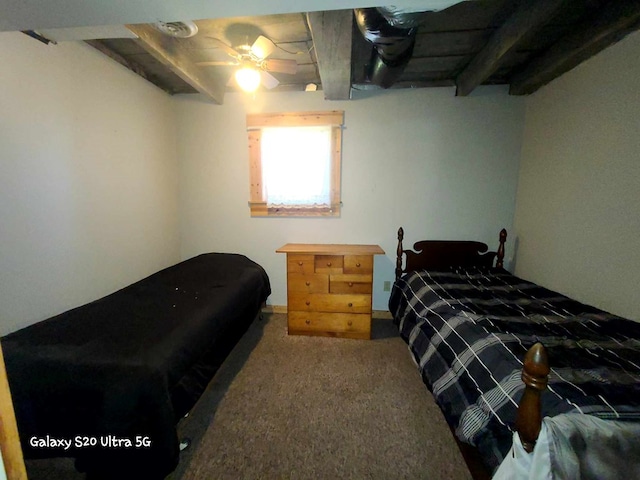 carpeted bedroom featuring beamed ceiling and ceiling fan