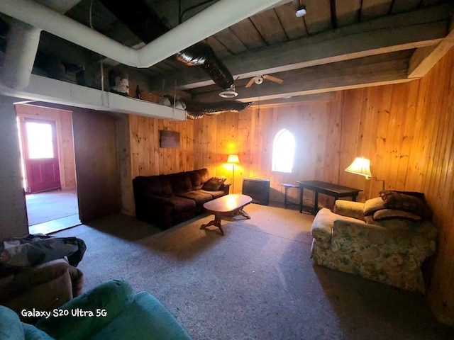 carpeted living room featuring wood walls