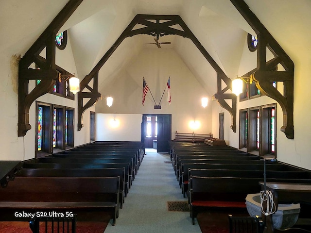 miscellaneous room with carpet and high vaulted ceiling