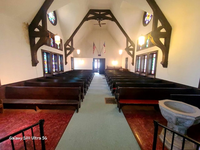 misc room featuring carpet floors and high vaulted ceiling