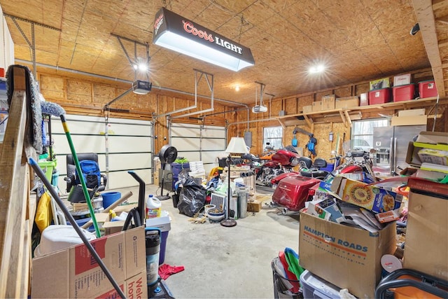 garage featuring stainless steel refrigerator with ice dispenser and a garage door opener