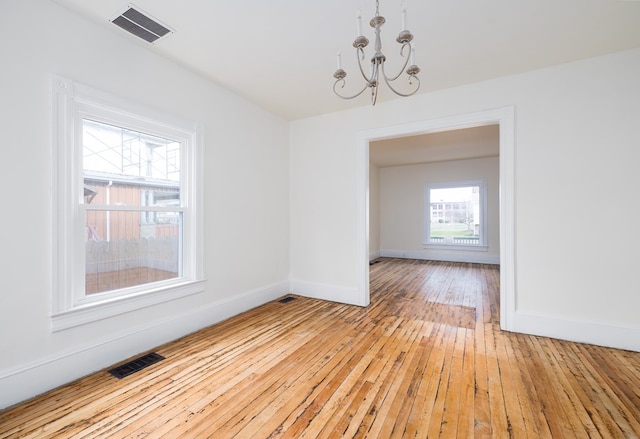 unfurnished dining area featuring light hardwood / wood-style flooring and a chandelier