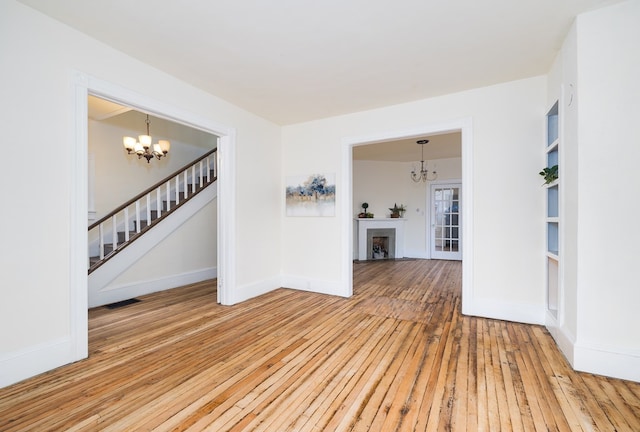 empty room featuring hardwood / wood-style flooring and an inviting chandelier