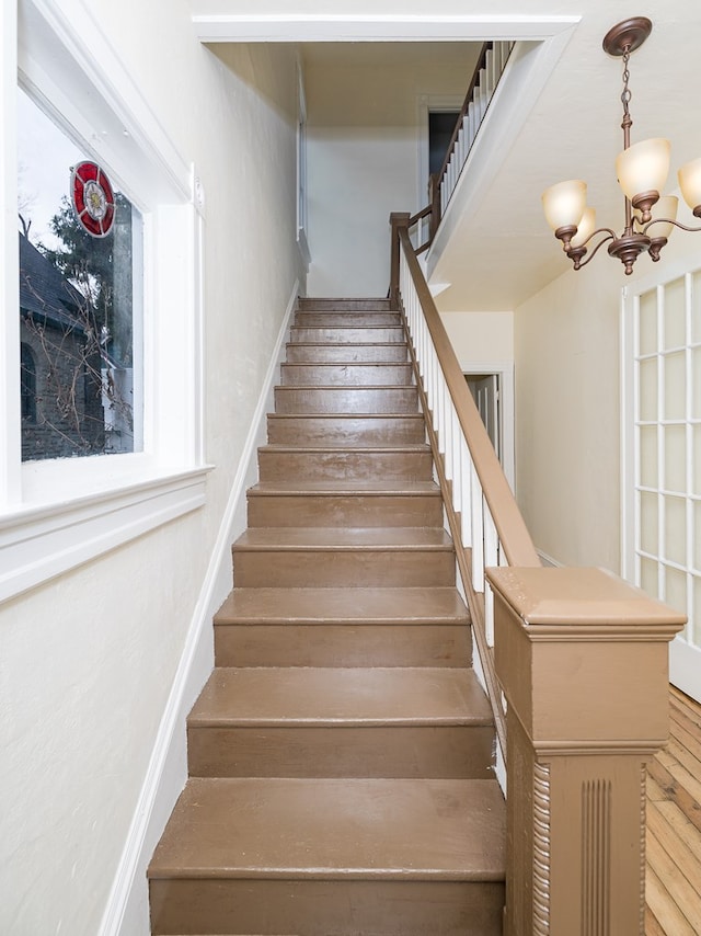 staircase with a chandelier