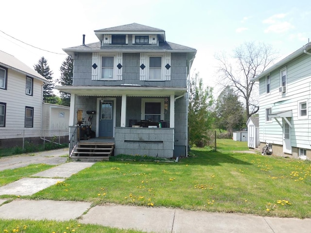 traditional style home featuring a porch, a shingled roof, and a front yard