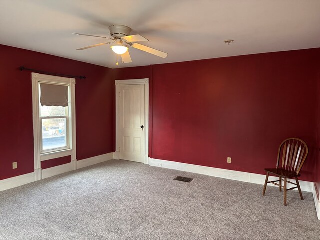 carpeted empty room featuring ceiling fan