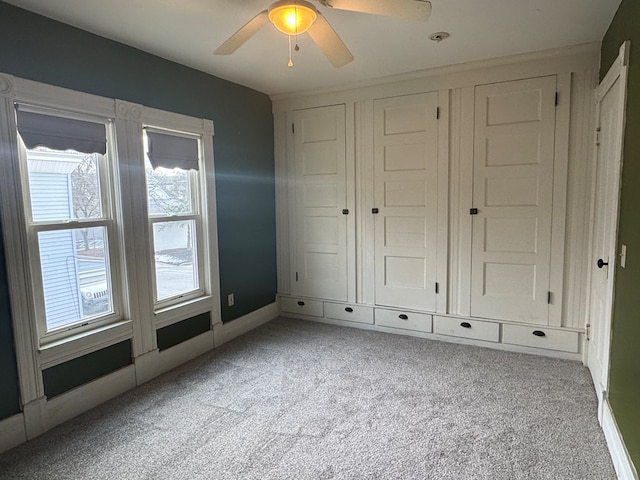 unfurnished bedroom featuring ceiling fan and light colored carpet