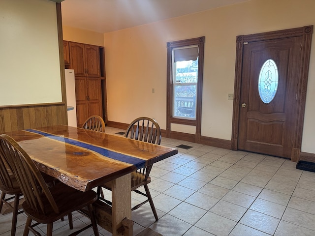 tiled dining area featuring wooden walls