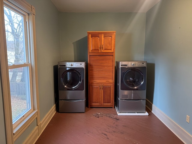 clothes washing area featuring hardwood / wood-style flooring, cabinets, and washing machine and clothes dryer