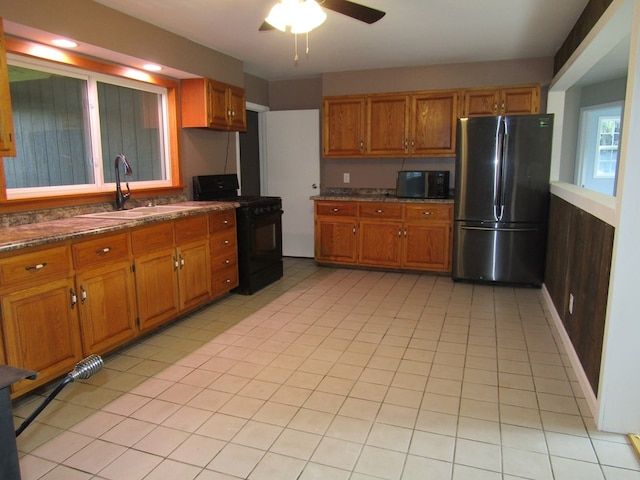 kitchen featuring black range, ceiling fan, sink, and stainless steel refrigerator