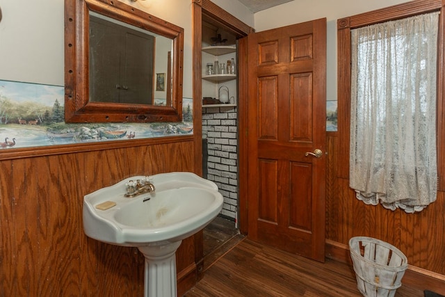 bathroom featuring sink, wood-type flooring, and wood walls