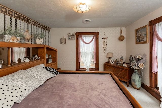 carpeted entryway with a textured ceiling