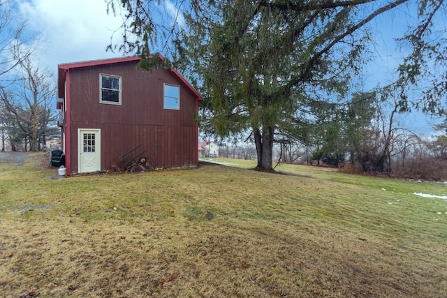 view of home's exterior featuring an outbuilding and a lawn