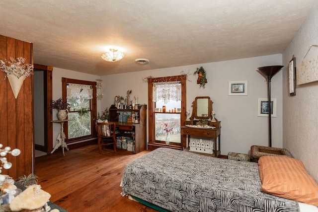 bedroom with hardwood / wood-style flooring and a textured ceiling