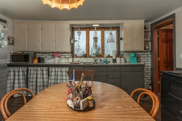 kitchen with tasteful backsplash, sink, gray cabinets, and range with electric cooktop