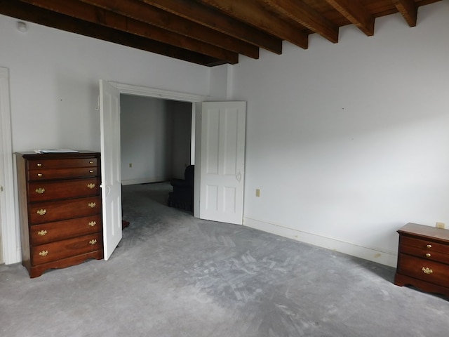 unfurnished bedroom featuring light carpet, beamed ceiling, and wood ceiling