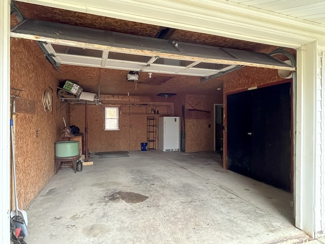 garage featuring a garage door opener and white refrigerator