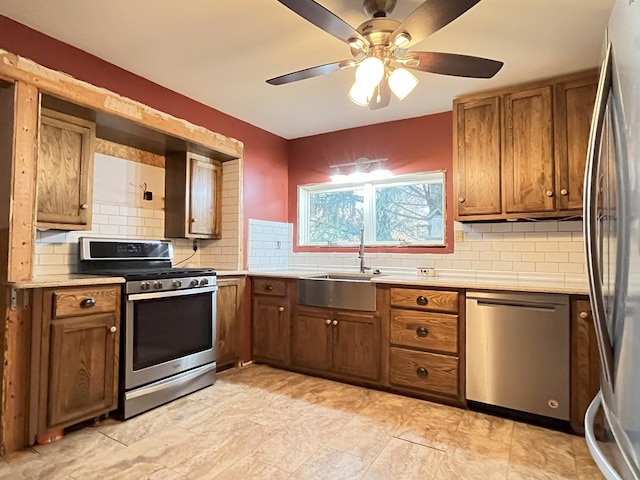 kitchen featuring backsplash, ceiling fan, sink, and appliances with stainless steel finishes