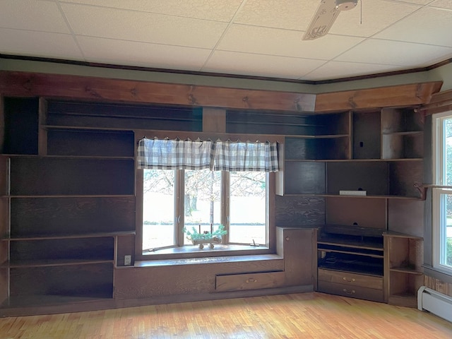 unfurnished living room featuring a paneled ceiling, light hardwood / wood-style flooring, baseboard heating, and ceiling fan