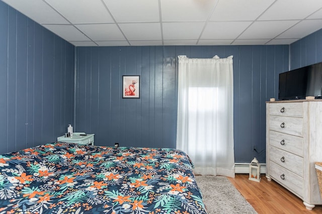 11 Purple St, Wellsboro, PA 16901 - bedroom with light wood-style floors, a baseboard radiator, and a paneled ceiling