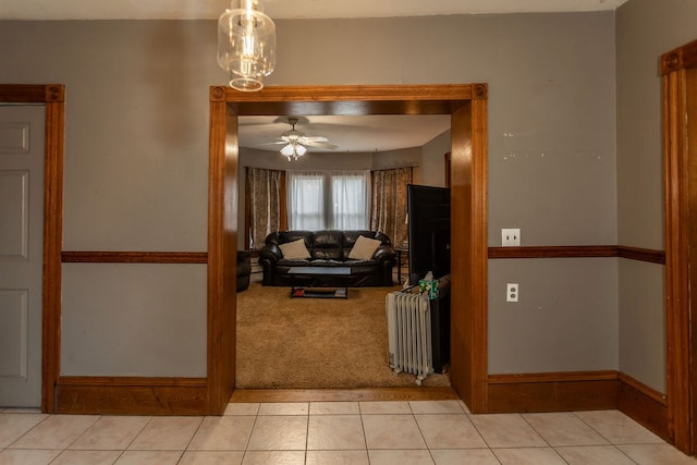 11 Purple St, Wellsboro, PA 16901 - living area with baseboards, radiator heating unit, light carpet, light tile patterned floors, and a ceiling fan