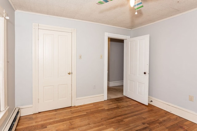 11 Purple St, Wellsboro, PA 16901 - empty room featuring crown molding, wood finished floors, baseboards, and a baseboard radiator