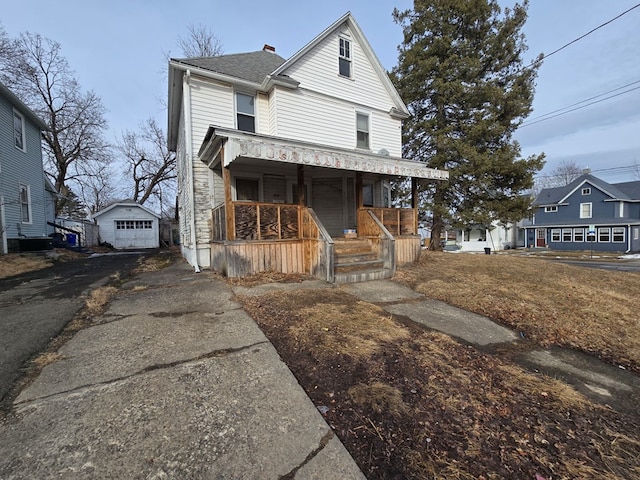 view of front facade featuring a garage, driveway, a porch, and an outdoor structure