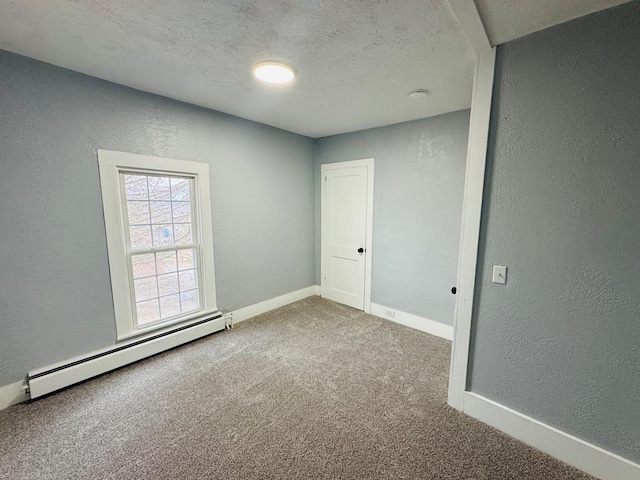 carpeted empty room with a baseboard heating unit, a textured wall, a textured ceiling, and baseboards