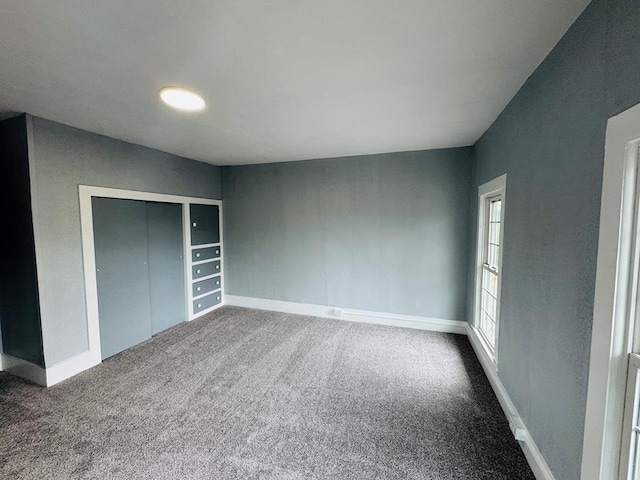 unfurnished bedroom featuring a closet, baseboards, and carpet flooring