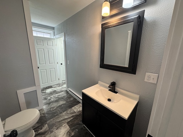 bathroom featuring toilet, a baseboard radiator, vanity, and a textured wall