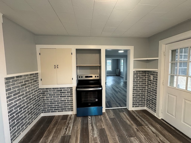 interior space with open shelves, dark wood-type flooring, stainless steel electric range, and brick wall