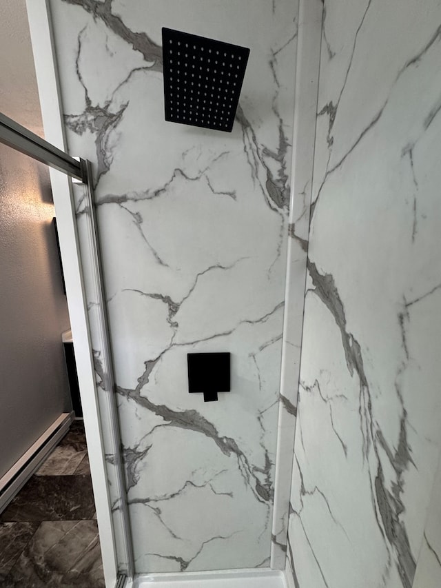 room details featuring a marble finish shower and baseboard heating