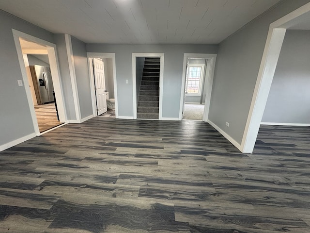 interior space featuring stainless steel fridge, dark wood finished floors, and baseboards