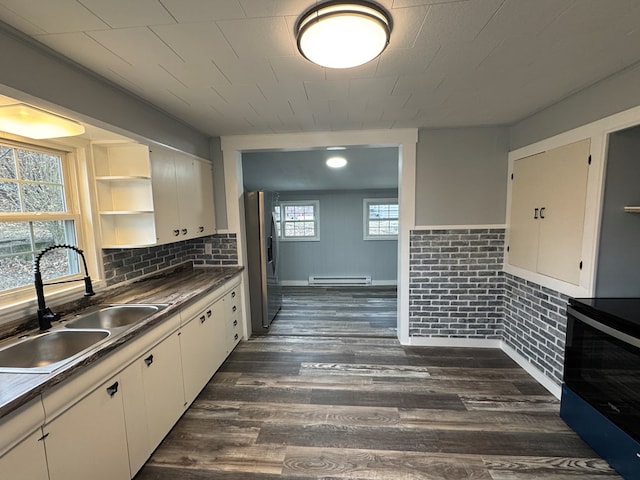 kitchen with stainless steel fridge, dark wood finished floors, electric stove, a baseboard radiator, and a sink