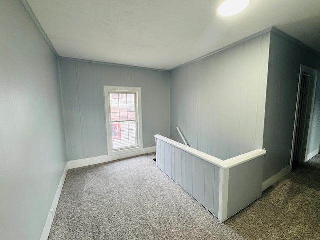 interior space featuring carpet floors, an upstairs landing, and baseboards