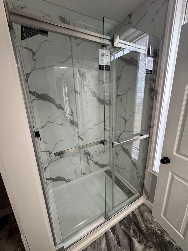 full bathroom featuring marble finish floor and a marble finish shower