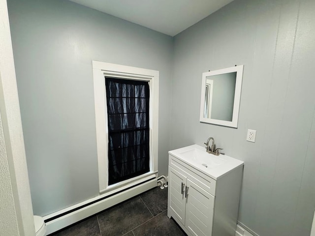 half bathroom featuring toilet, vanity, and baseboard heating