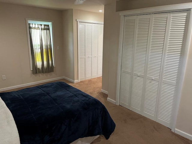 bedroom with carpet flooring and two closets