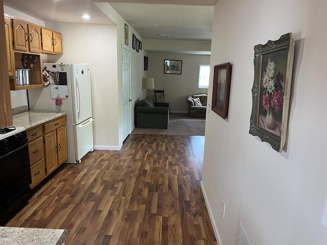 kitchen with white refrigerator, black range, and dark wood-type flooring