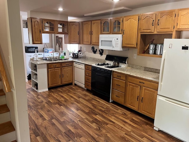 kitchen with light stone countertops, sink, dark wood-type flooring, and white appliances