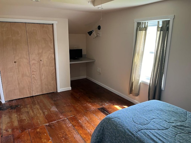 bedroom with dark hardwood / wood-style floors and built in desk