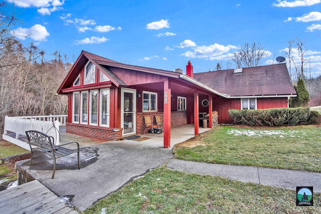 back of house with a lawn and a patio