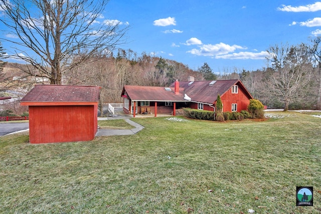 view of front of house featuring a front yard and a storage unit