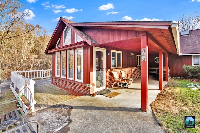 rear view of property with a wooden deck and a patio area