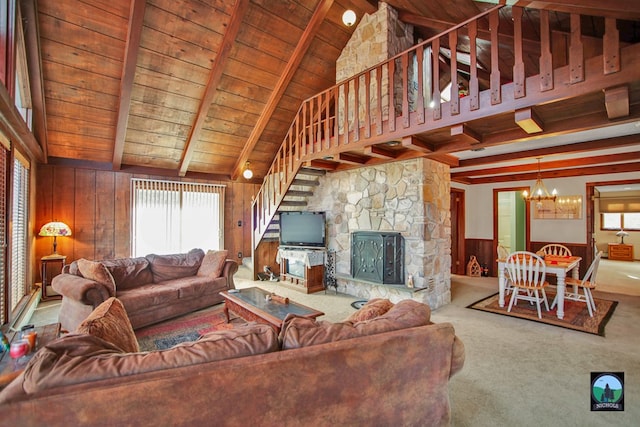 living room with a stone fireplace, wood walls, beamed ceiling, a chandelier, and wood ceiling