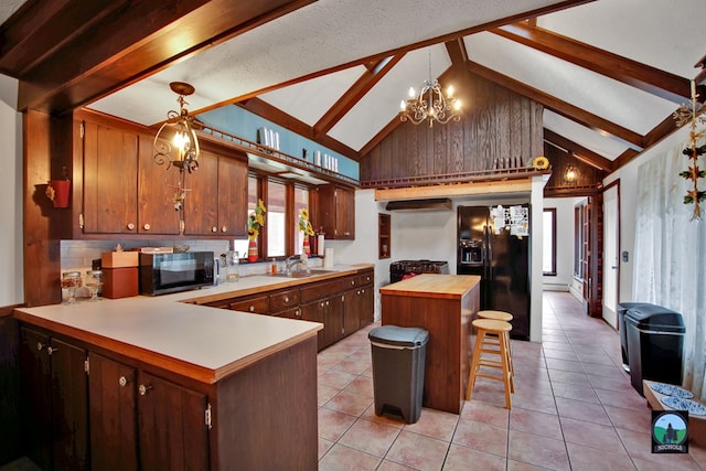 kitchen featuring sink, an inviting chandelier, black fridge with ice dispenser, decorative light fixtures, and kitchen peninsula