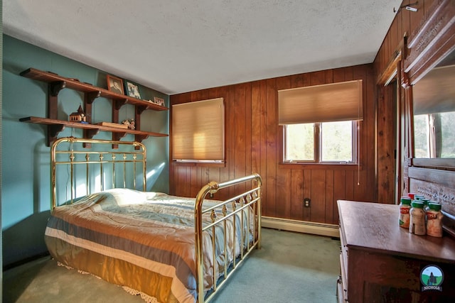 bedroom with carpet floors, a baseboard heating unit, wooden walls, and a textured ceiling