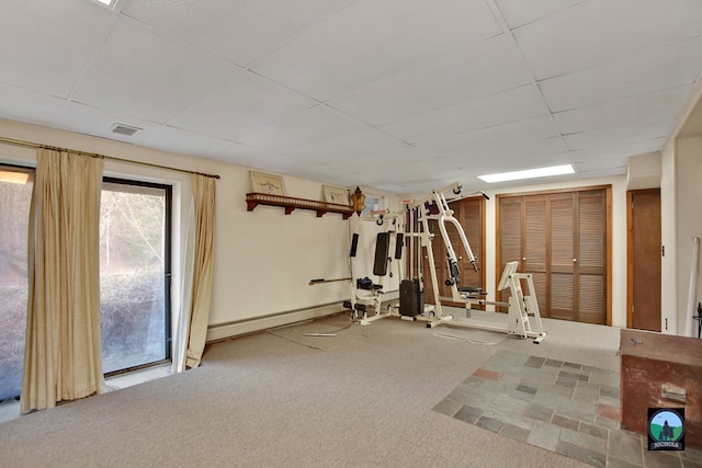 exercise area featuring a drop ceiling, baseboard heating, and carpet