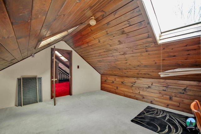 additional living space with wood ceiling, carpet, vaulted ceiling with skylight, and wood walls