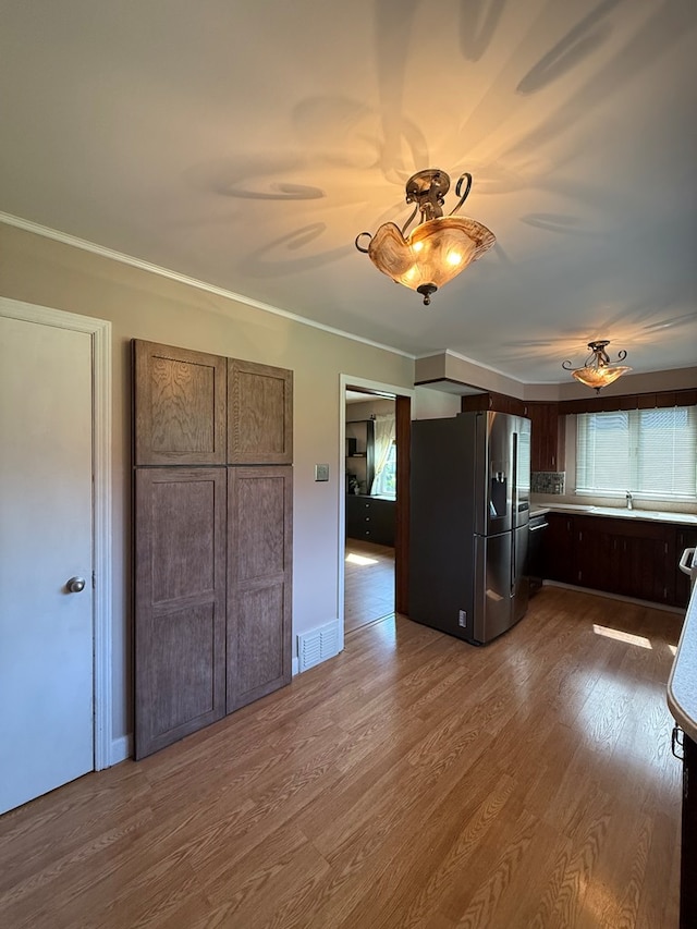 922 W Lockhart St, Sayre, PA 18840 - kitchen featuring stainless steel fridge, dark wood finished floors, ornamental molding, dark brown cabinetry, and light countertops